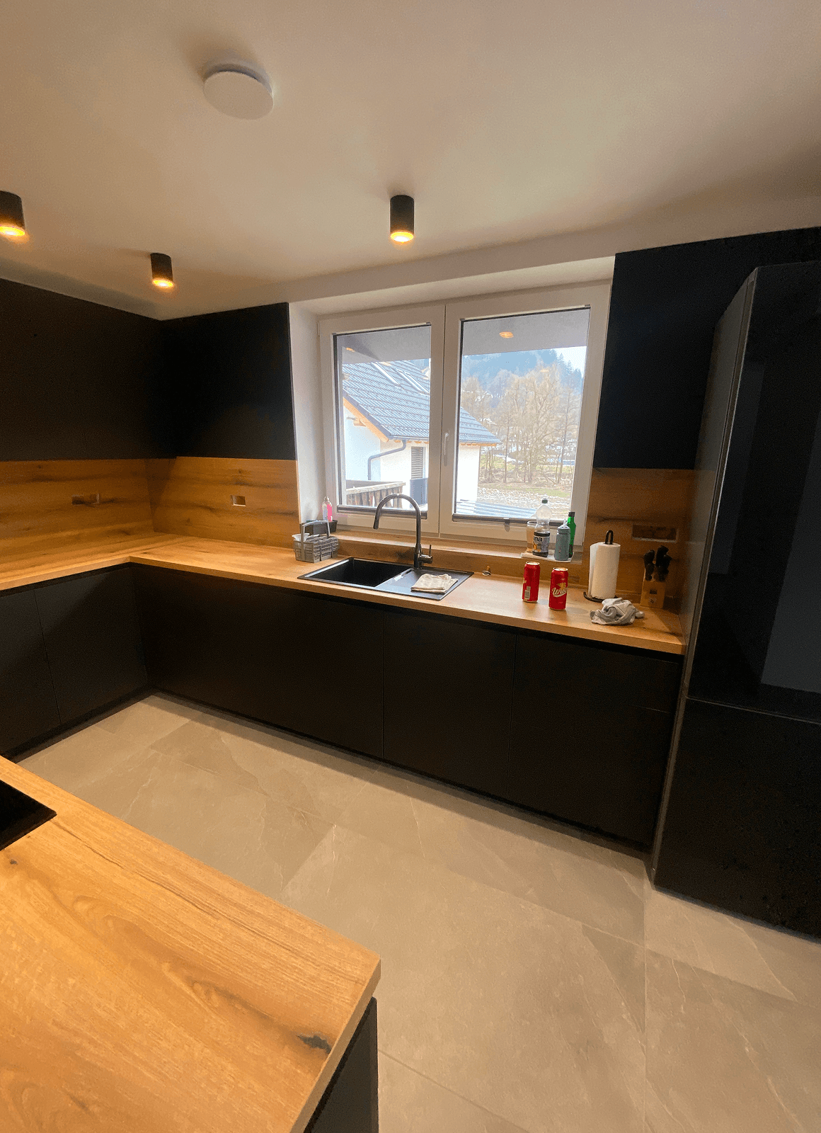 Sodobna črna kuhinja s hrastovim pultom